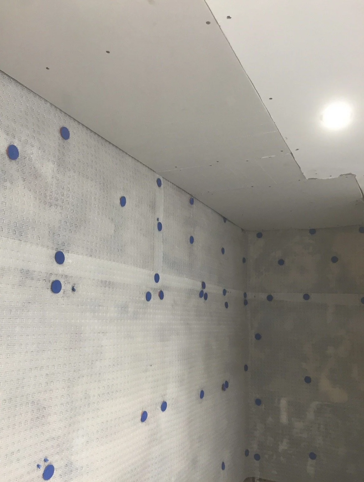 Studded cavity drain membrane mechanically fixed to the exposed wall as part of the damp-proofing system.