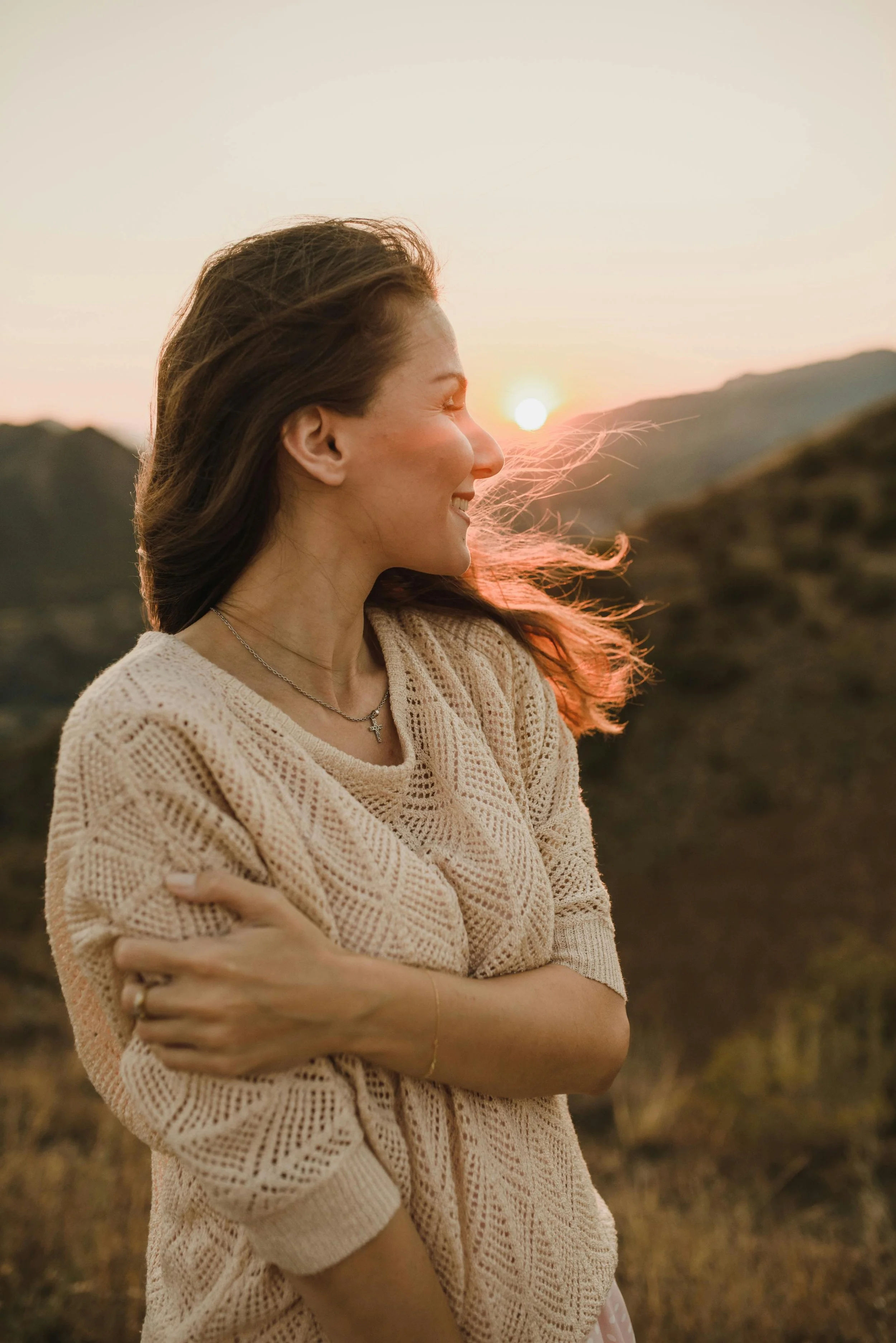 woman happy looking at distant mountains setting sun after healing from narcissistic relationships
