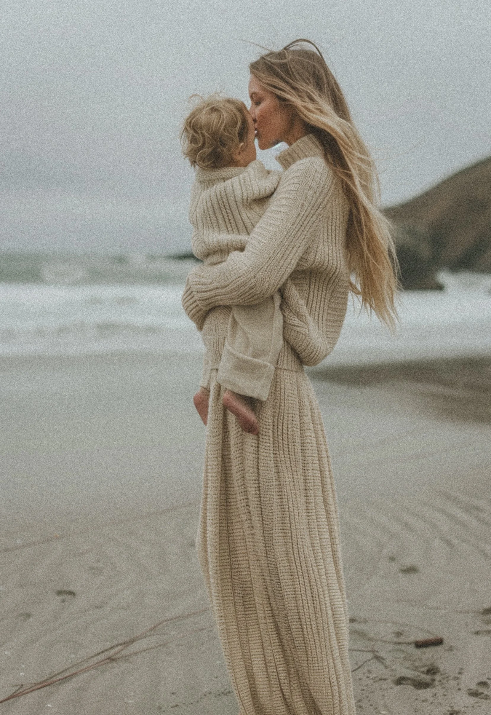woman kissing child on beach feeling connected and present.