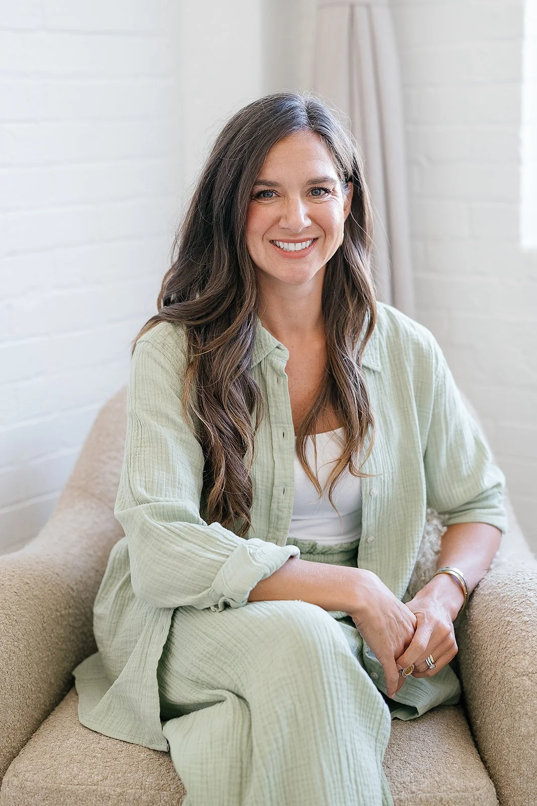 Jessica Ortiz, LCSW therapist and owner of Catalyst Therapy & Consulting smiling sitting in a cozy chair