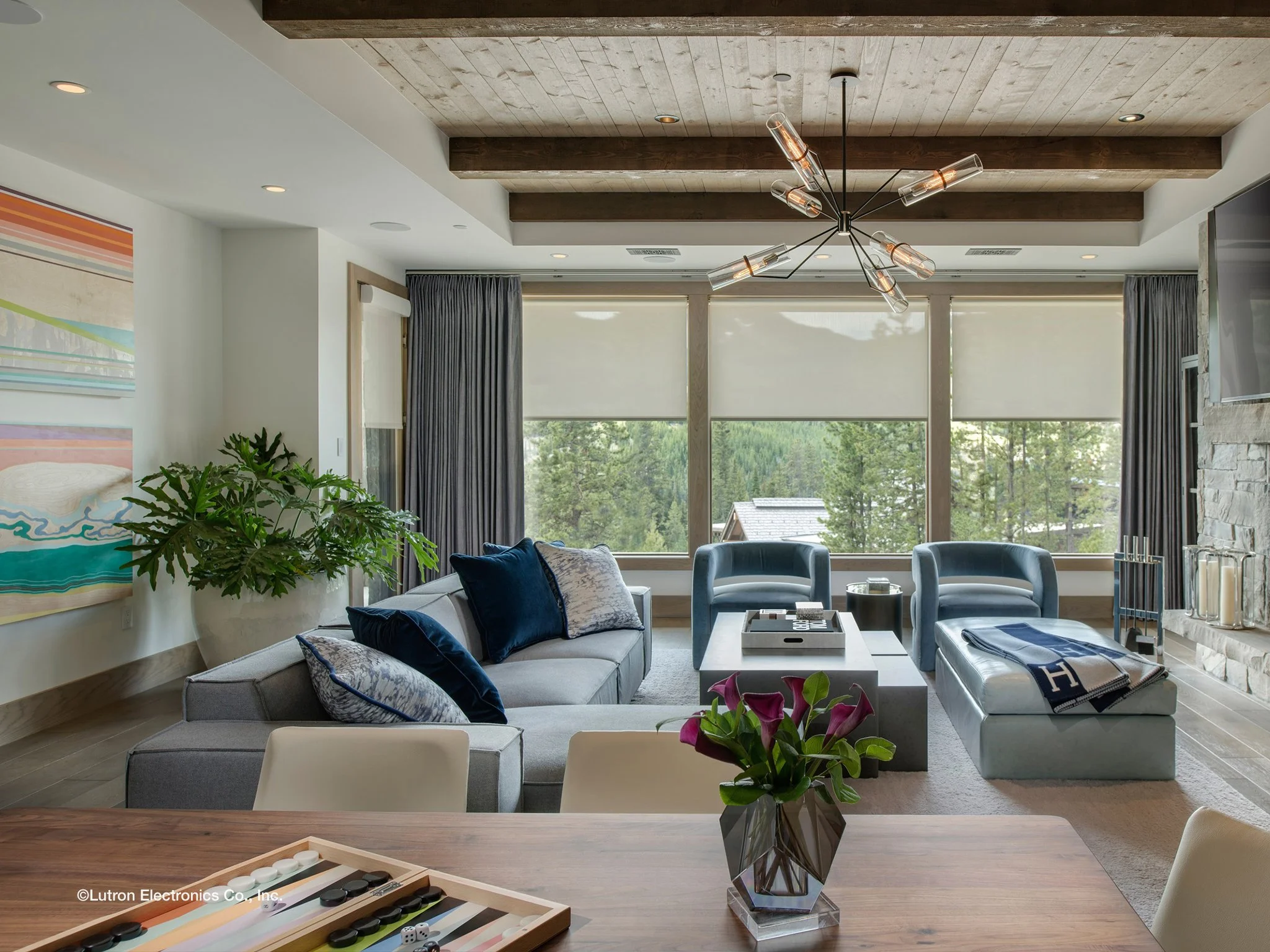 Modern living room with custom roller shades and layered drapery by Smart Shade Studio, featuring Lutron smart shades and Clara Shades for light control and energy efficiency.