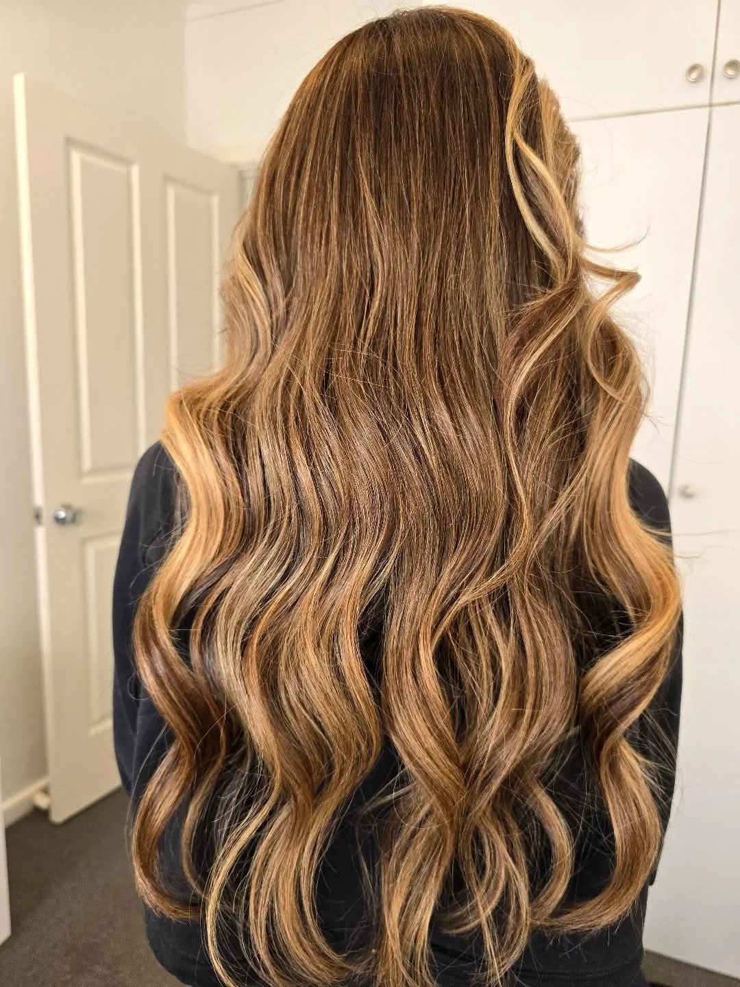 Long, wavy, light brown hair with highlights.