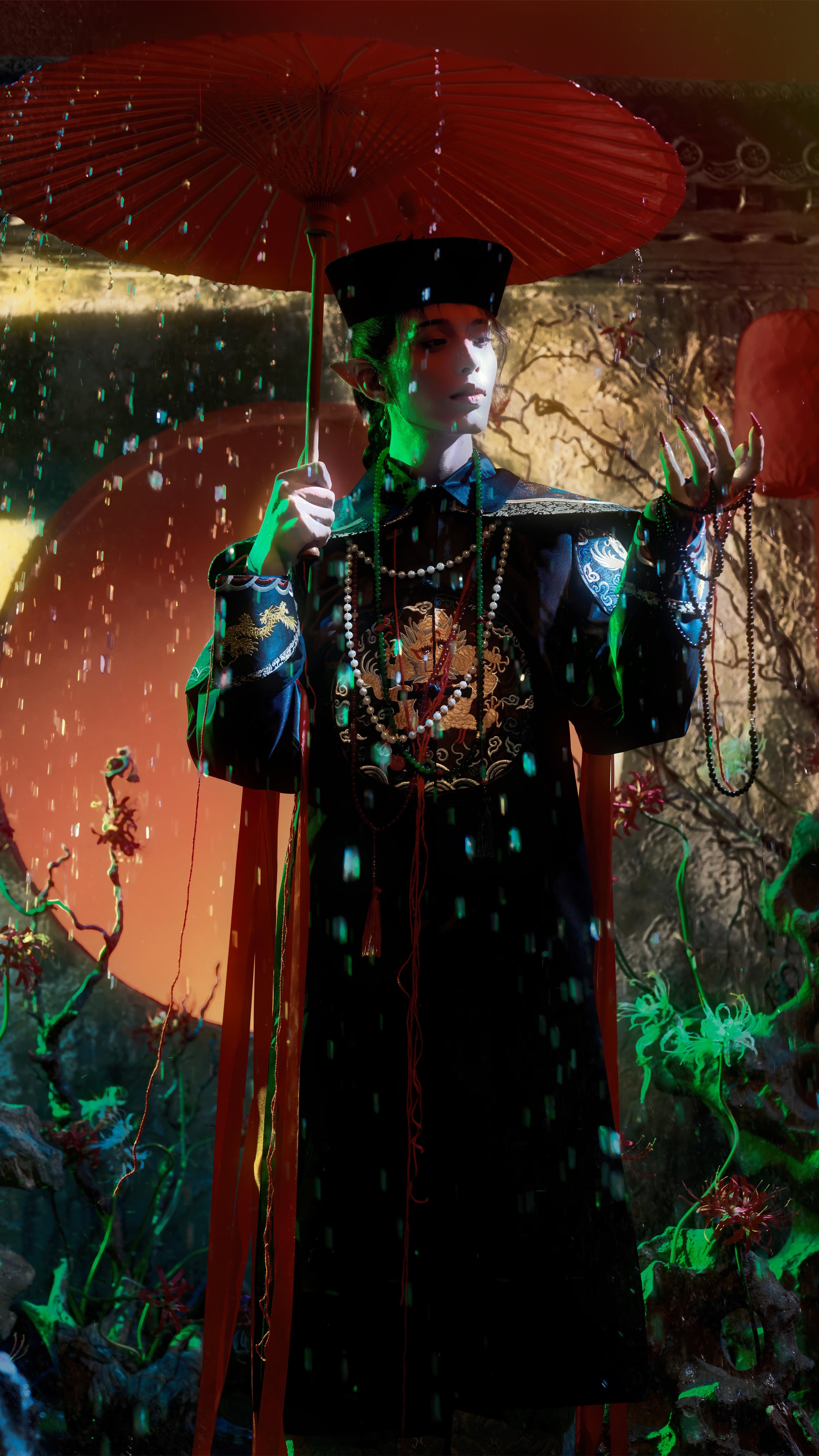 A woman dressed in an elaborate black costume with embroidered dragon motifs, wearing pearl necklaces and a tall black hat, holding a red paper parasol under rain in a fantastical setting with glowing green plants and a large orange moon in the backg