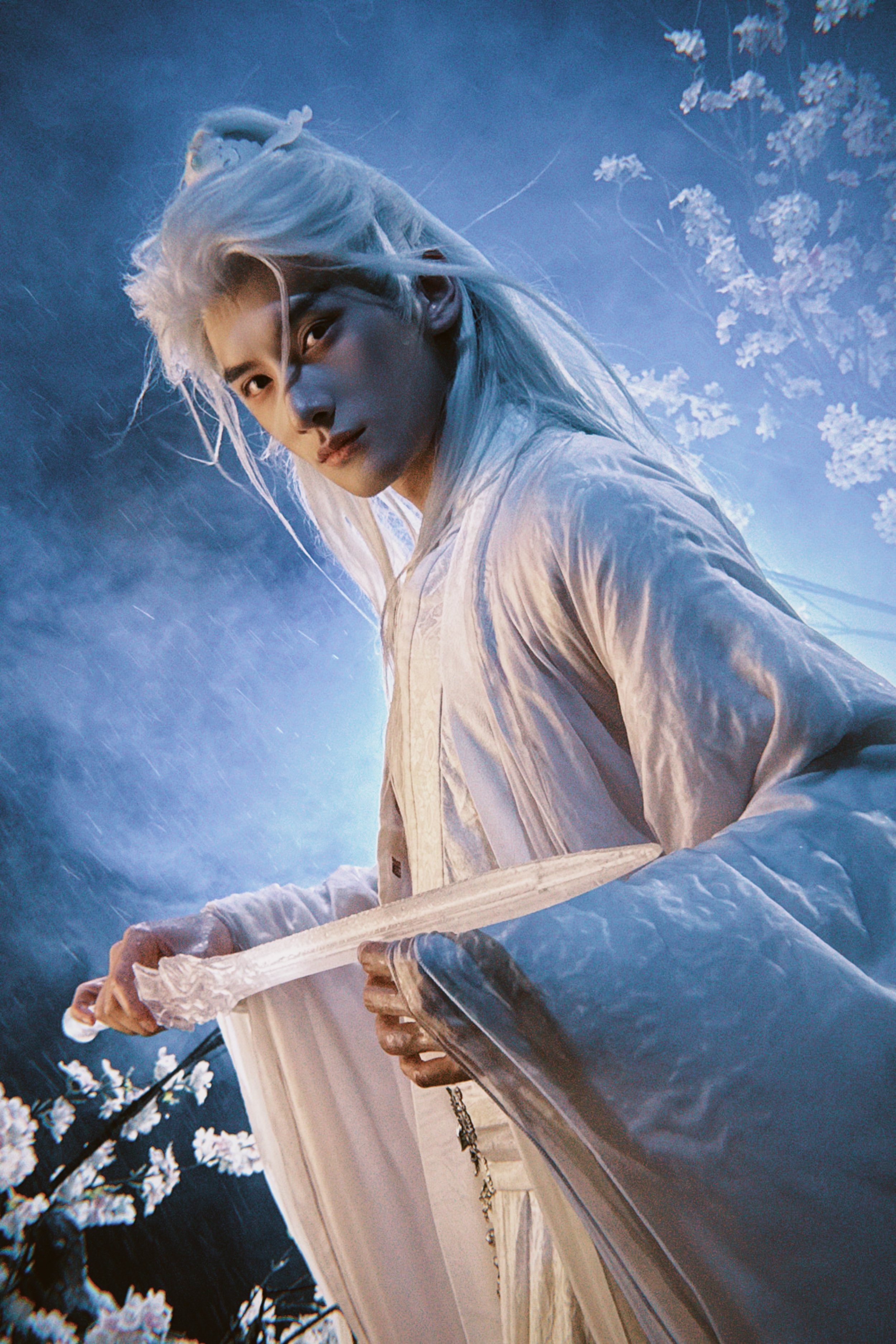 A person with long, light-colored hair dressed in traditional Asian-inspired clothing, holding a sword with rain falling and a background of blossoming flowers and misty sky.