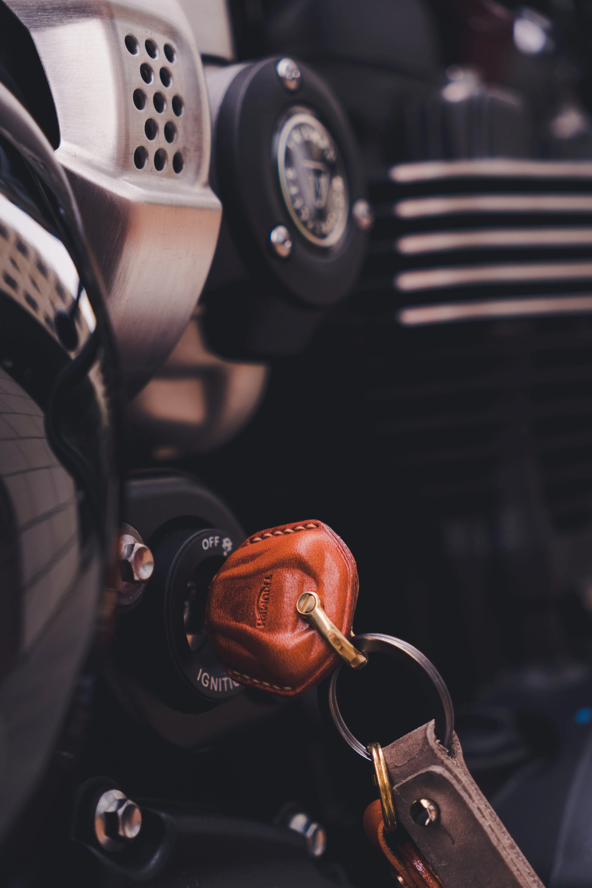 Close-up of a car dashboard with a leather key fob in the ignition.