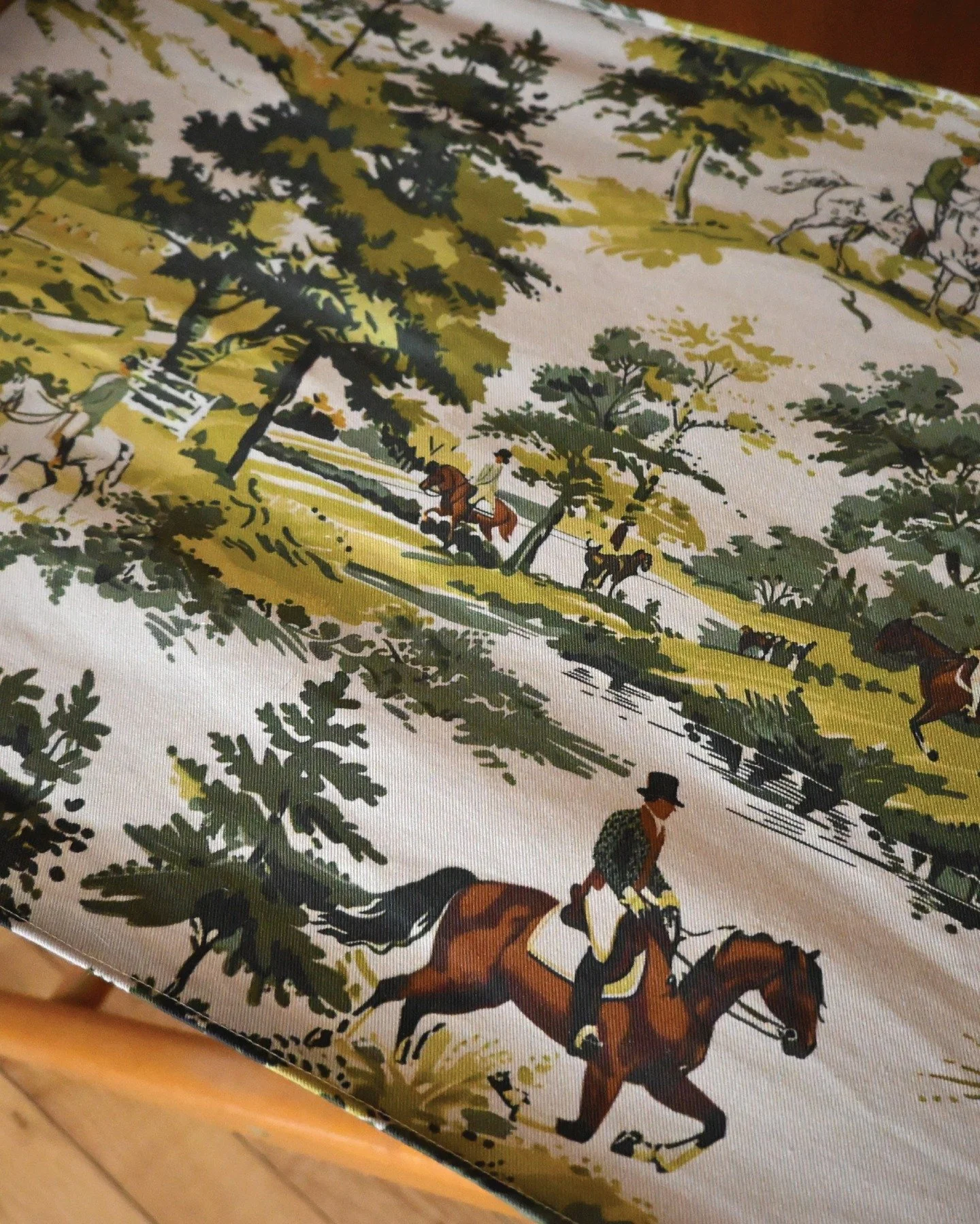 Sneak peak of a director's chair given second life with vintage hunting scene fabric. Horses, hounds, forest green. Ready for its new home.