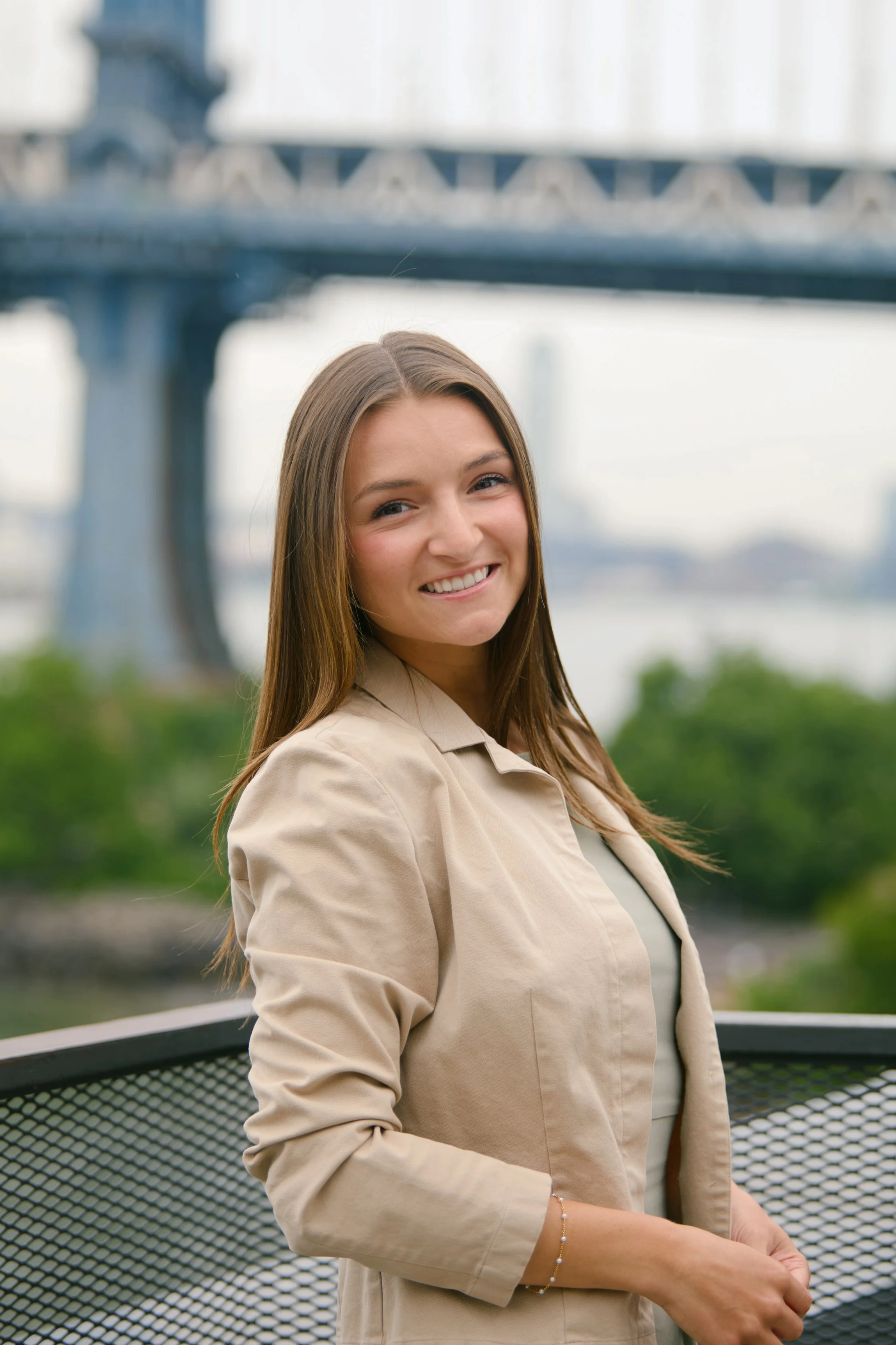 Professional headshot of Sabina Crisitello smiling in front of the Brooklyn Bridge.