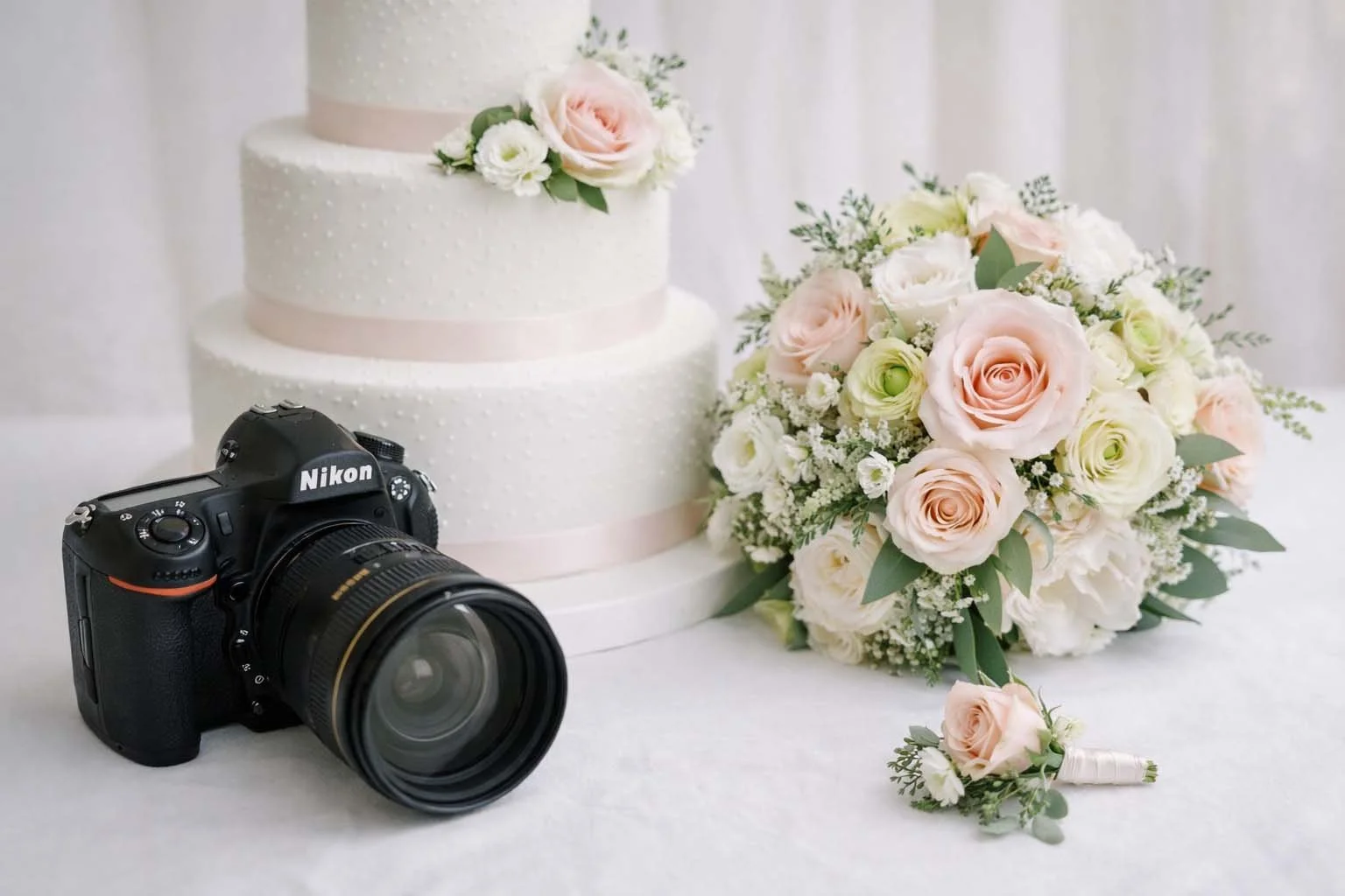 Wedding cake, Nikon camera, bridal bouquet on a wedding table. OBX Outer Banks wedding officiant.