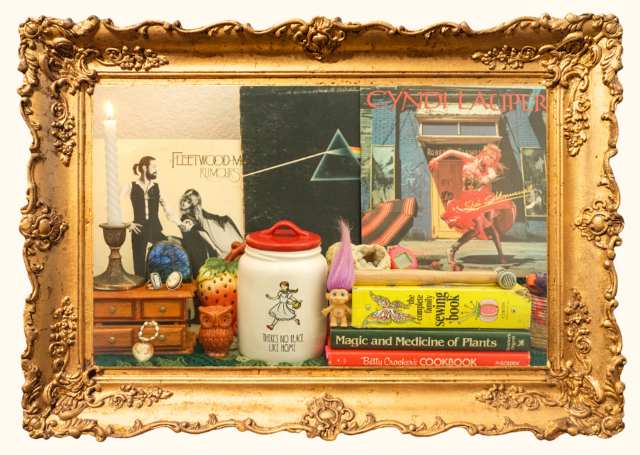 Decorative display case with various books, figurines, and decorative objects, including a Fleetwood Mac Rumours album cover and a Pink Floyd The Dark Side of the Moon poster in the background.