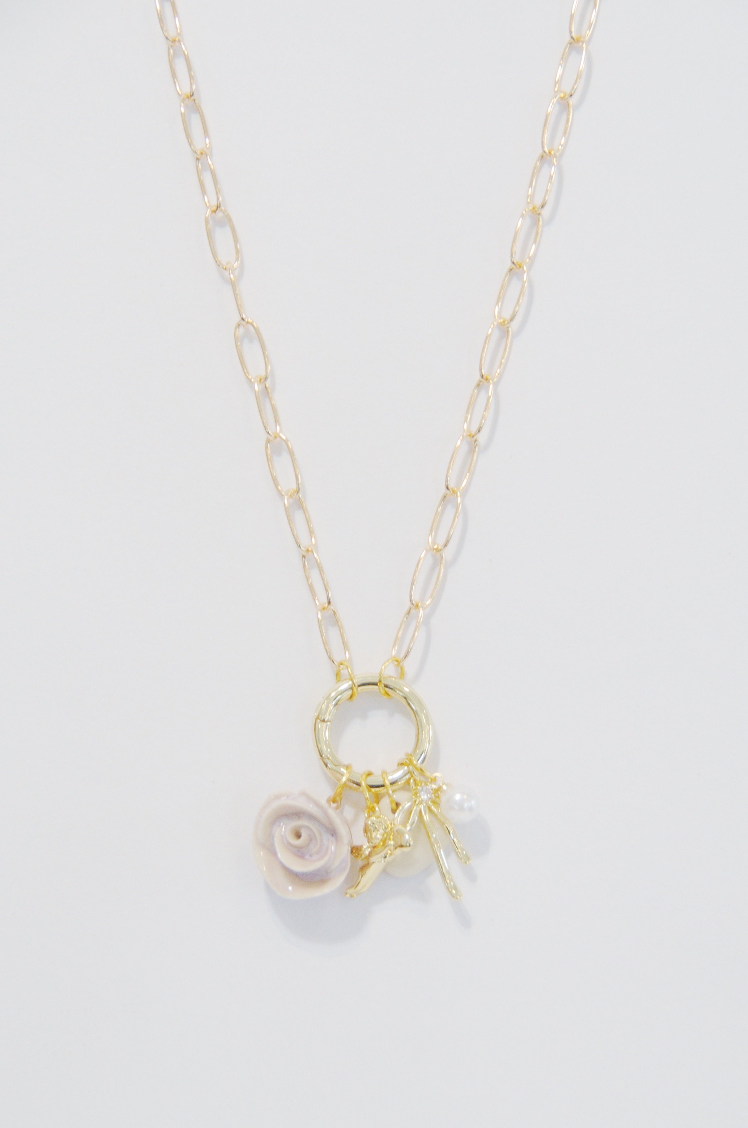Gold chain necklace with pearl and shell charms against a white background.