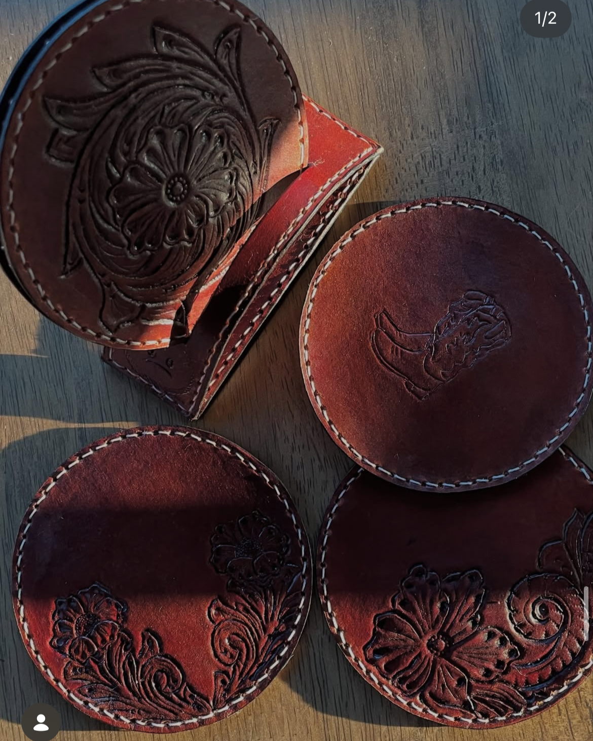 Three round leather coasters with embossed floral and butterfly designs, placed on a wooden surface. One coaster has a floral pattern, another has a butterfly, and the third features a design of a woman’s face.