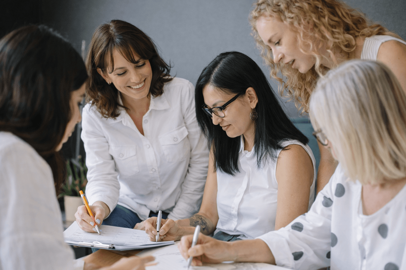 Team collaborating around a table with strategy documents and notes.