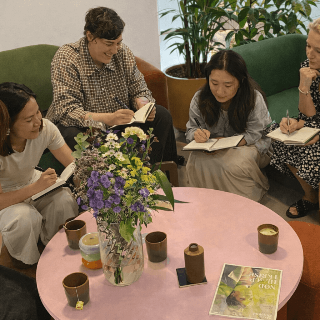 Group coaching session with participants reviewing reflection cards around a table.