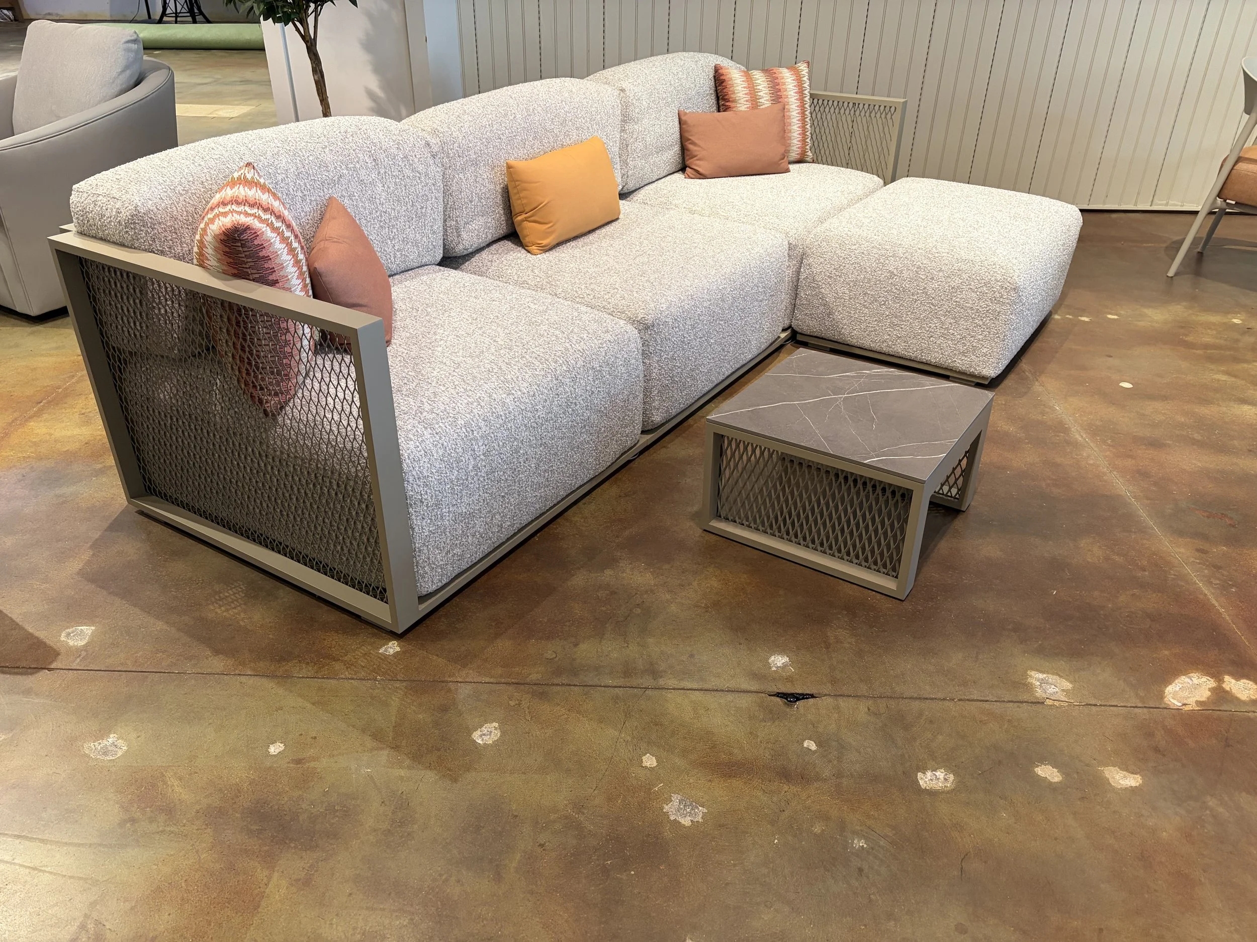 A modern living room sofa with throw pillows in an indoor furniture store.
