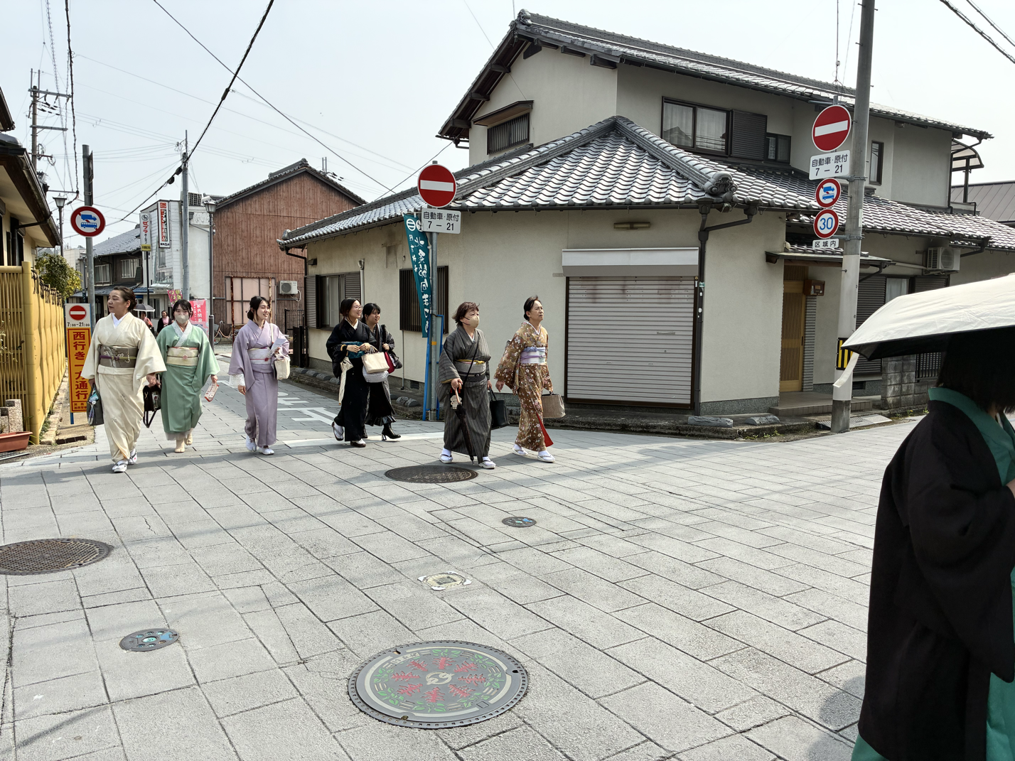 着物を着た女性たちが交差点を歩いている街の風景