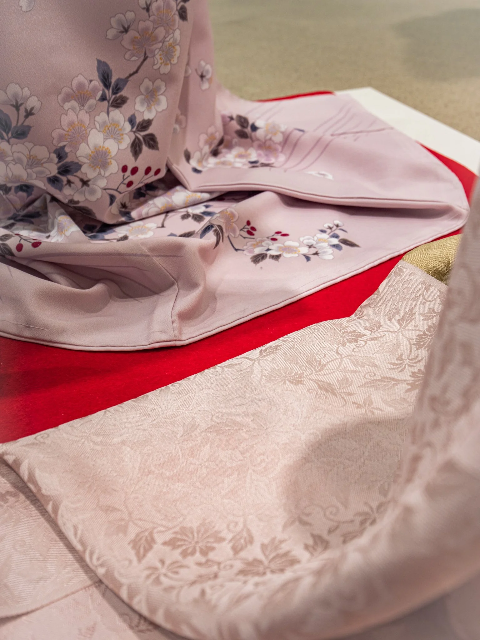 桜の花柄の着物が畳の上に広げられている画像