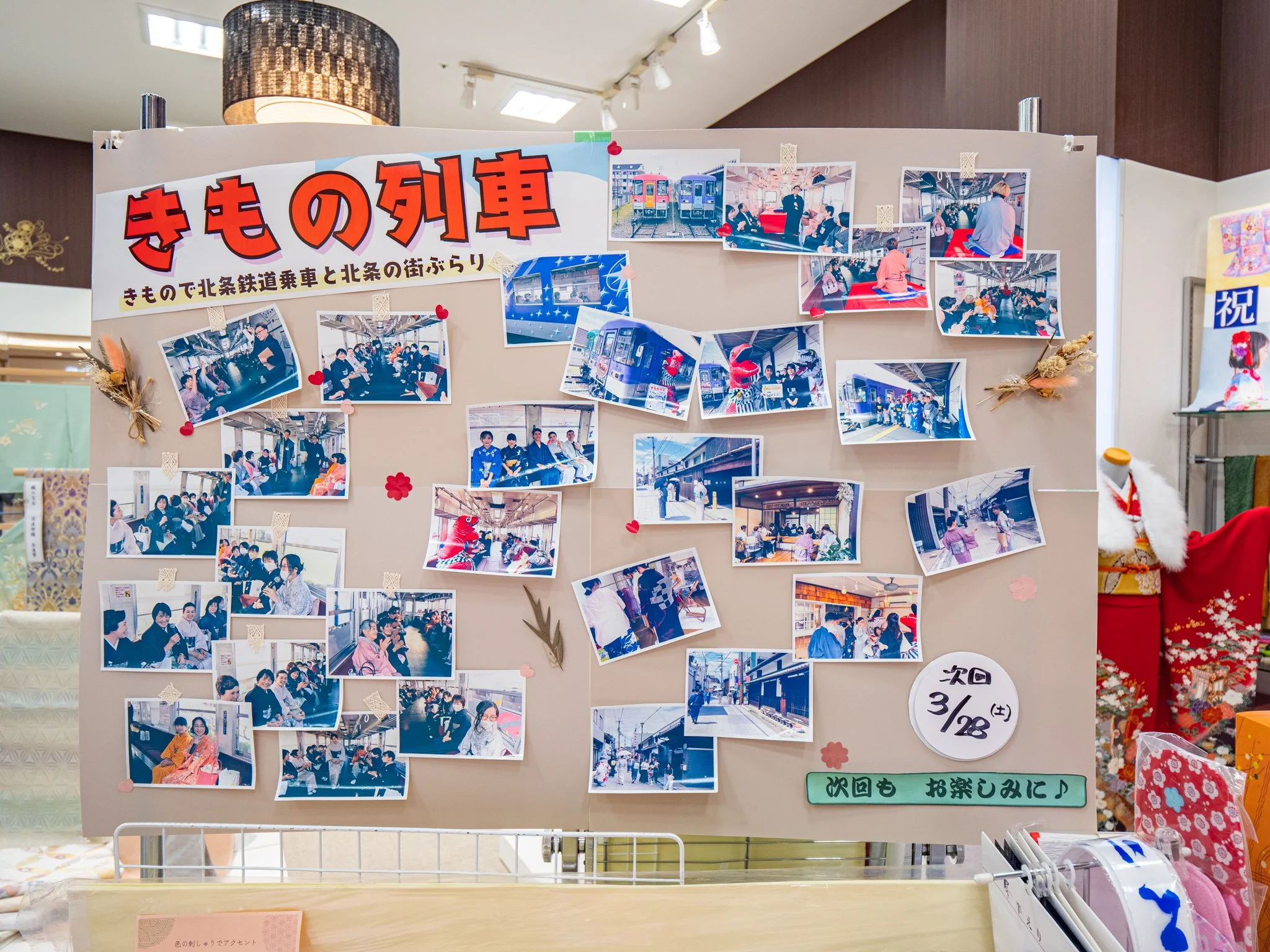 きもの列車の写真や展示を撮影した写真が貼られた掲示板です。タイトルは「きもの列車」と書かれており、下に「きもので北条鉄道乗車と北条の街ぶらり」と記載されています。多数の写真と飾りが貼られ、次回の開催予定日や案内も記載されています。