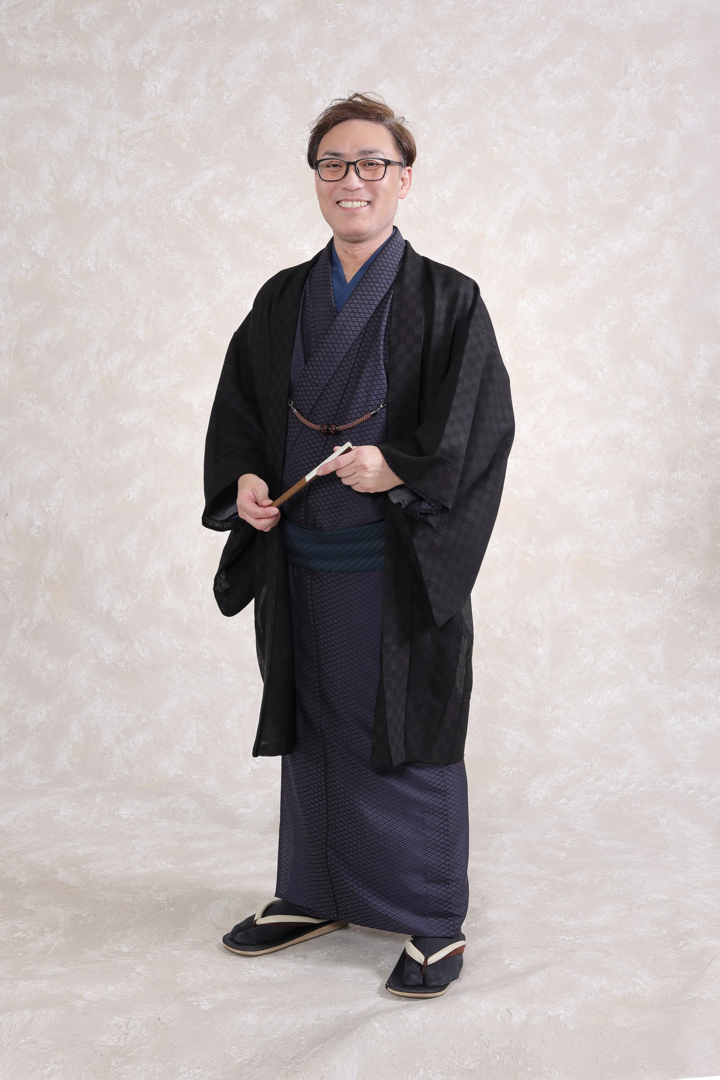 着物を着た男性が笑顔で立っている写真