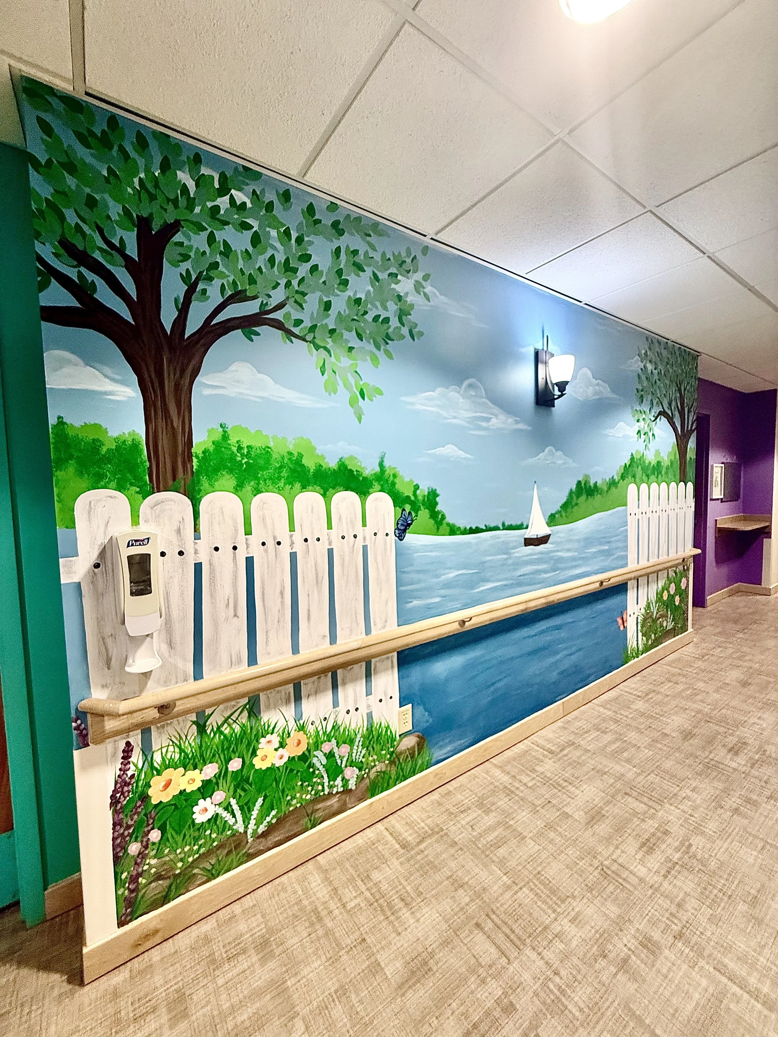 Dementia Ward scenic mural featuring a boat in water with trees and a fence with flowers and a butterfy