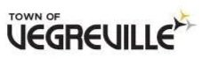 Logo of Town of Vegreville with stylized text and a small star-like graphic.