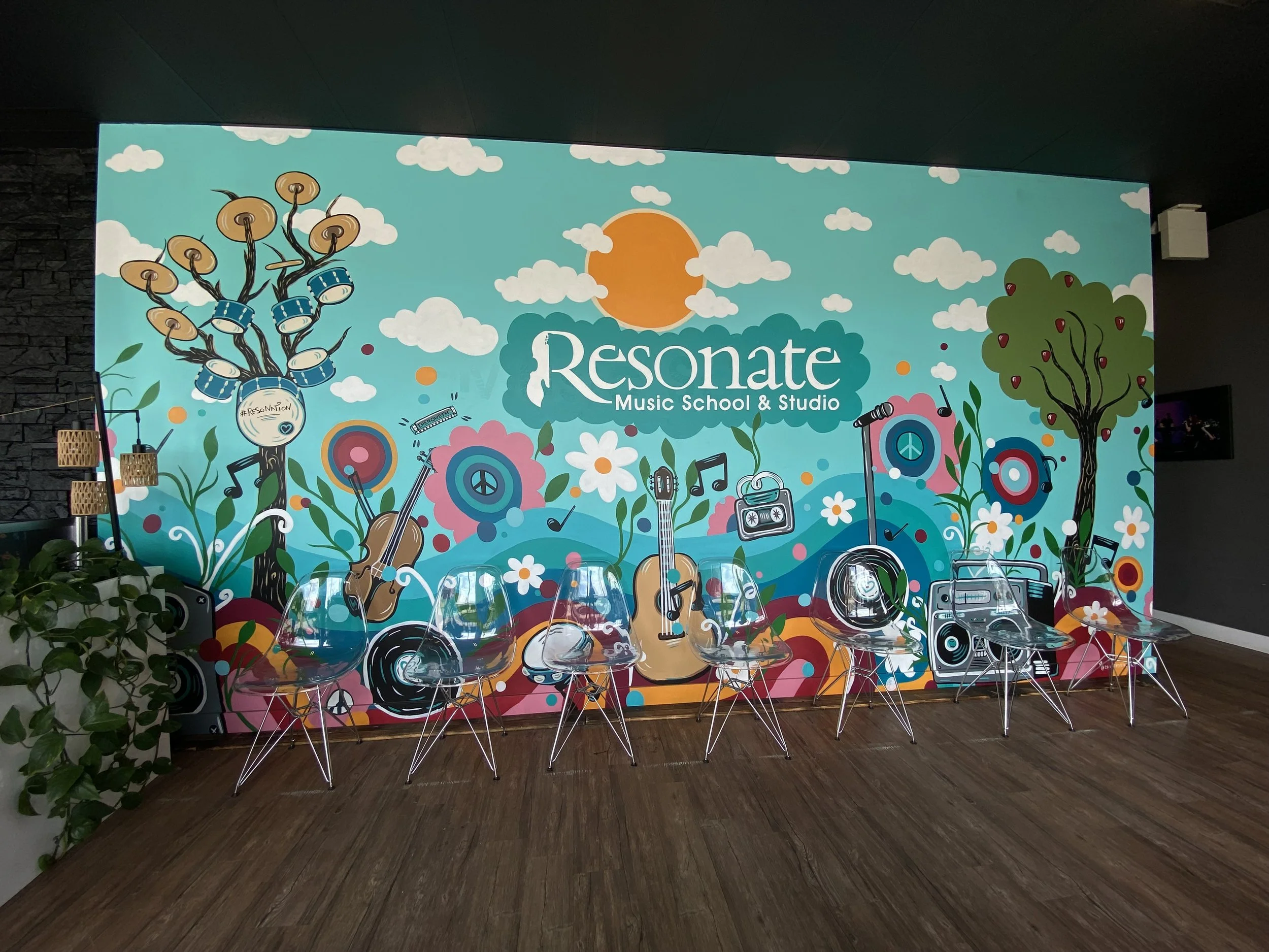 Colorful mural for Resonance Music School & Studio featuring trees, musical instruments, and decorative elements with a large sun at the center.
