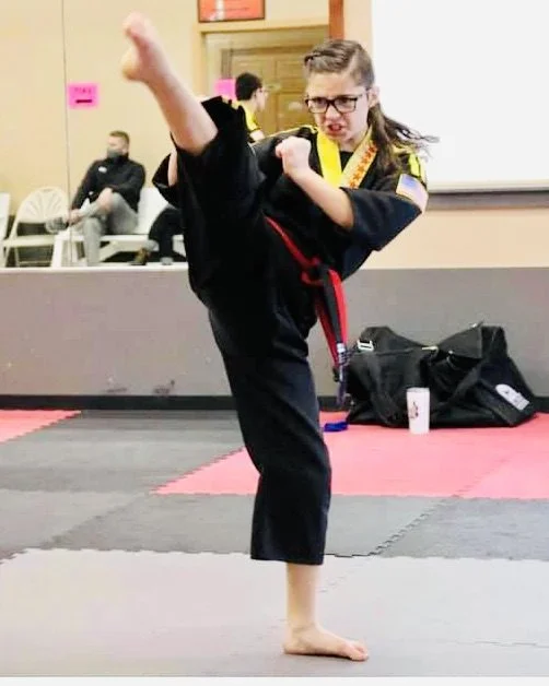 Teen girl kicking high in a martial arts and kenpo karate class in Cicero, NY and Liverpool, NY.
