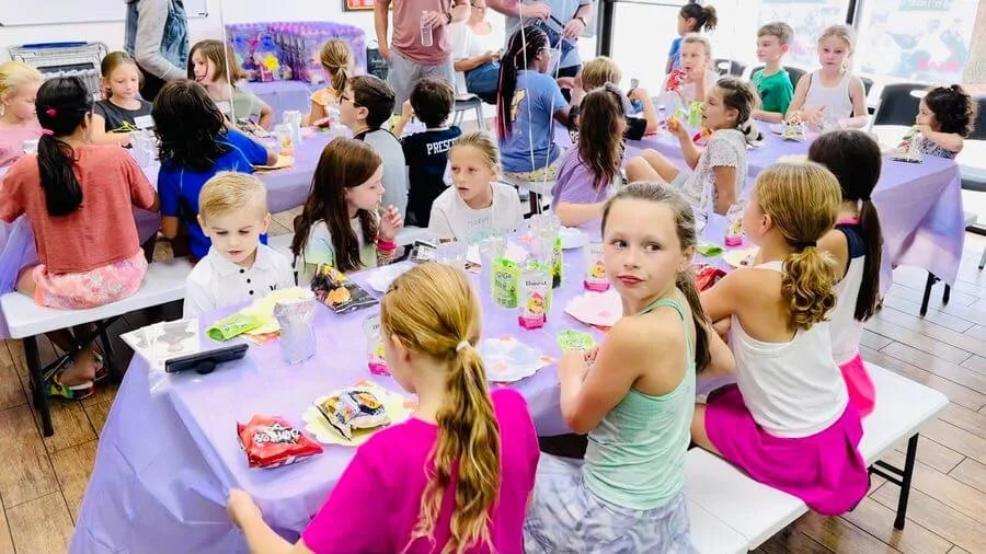 Group of kids sitting at a birthday party table at Karate John's Martial Arts centers in Cicero and Liverpool, NY.