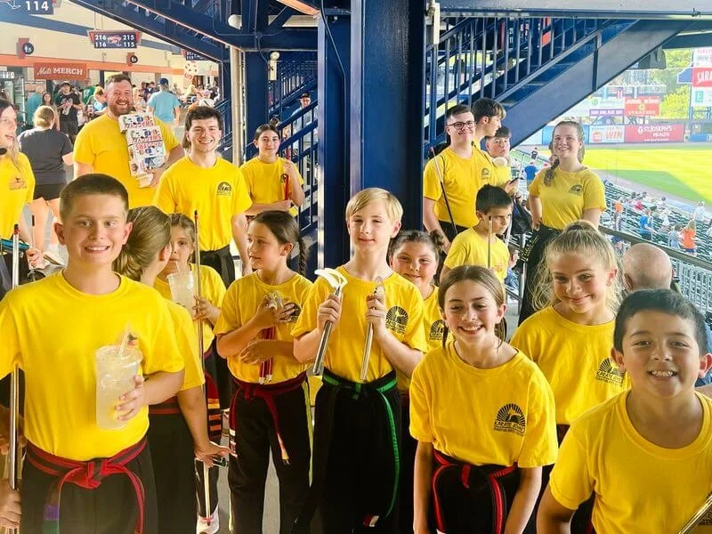Teen boys and girls with martial arts weapons smiling after public karate demonstration in Cicero and Liverpool, NY.
