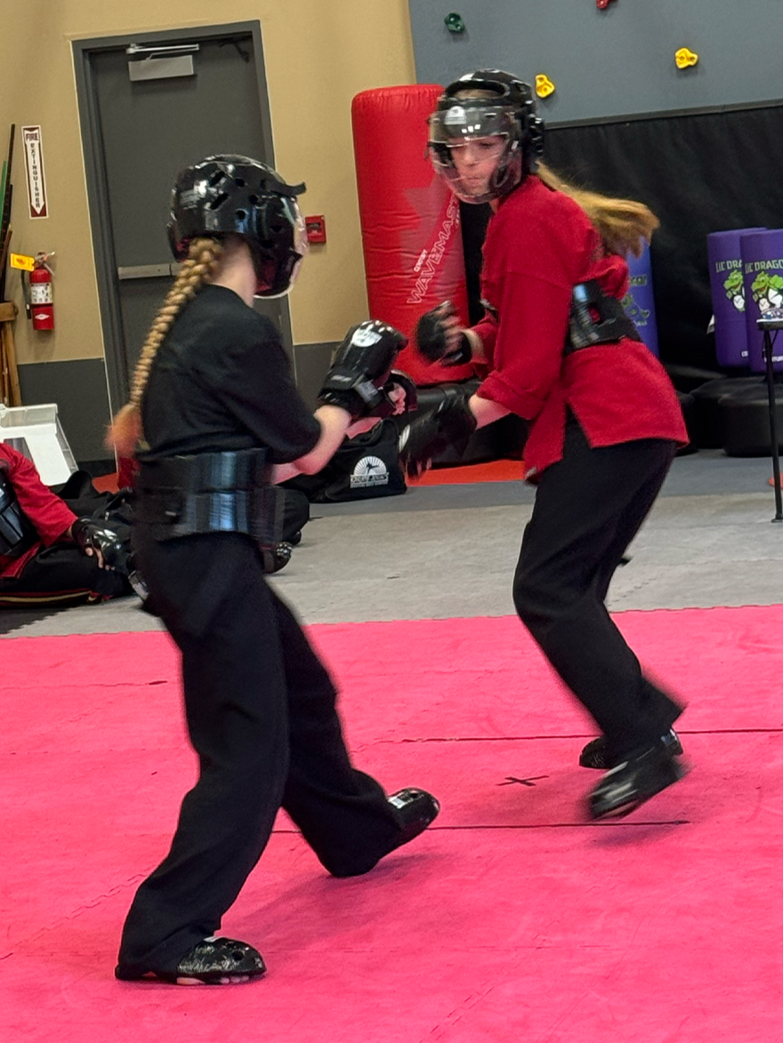 Teen girl practicing self-defense and take-down with her teen partner in a karate class in Cicero and Liverpool, NY.