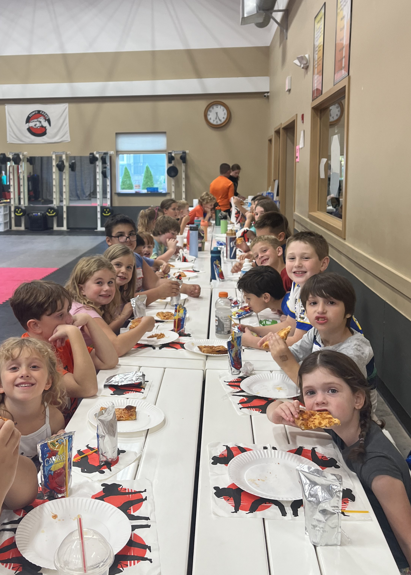 Group of kids sitting at a birthday party at Karate John's Martial Arts centers in Cicero and Liverpool, NY.