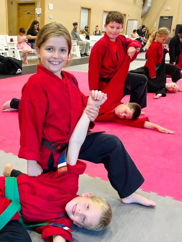 Girl practicing self-defense takedown in bully defense class for kids in Cicero and Liverpool, NY.