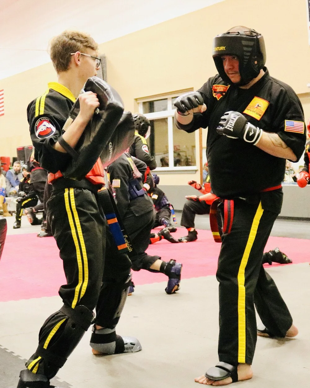 Adults in sparring gear practicing self-defense in karate class at Karate John's in Cicero, NY and Liverpool, NY.