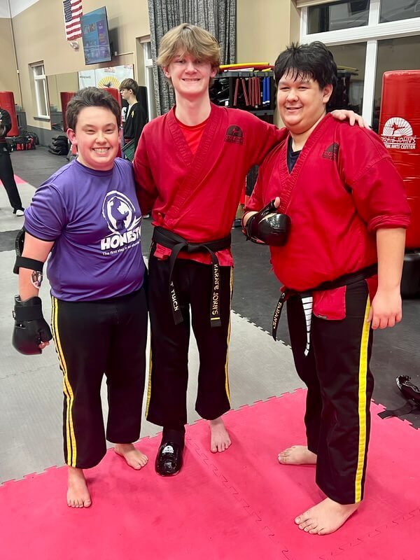 Adults hugging during martial arts and self-defense practice at Karate John's in Cicero, NY and Liverpool, NY.