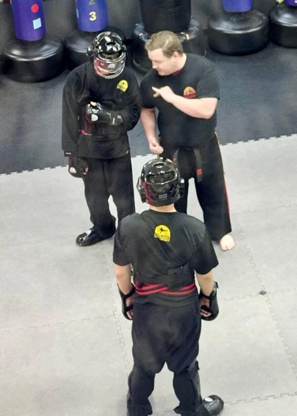 Karate instructor coaching students before supervised sparring practice at Karate John’s Martial Arts Center in Cicero and Liverpool, NY.