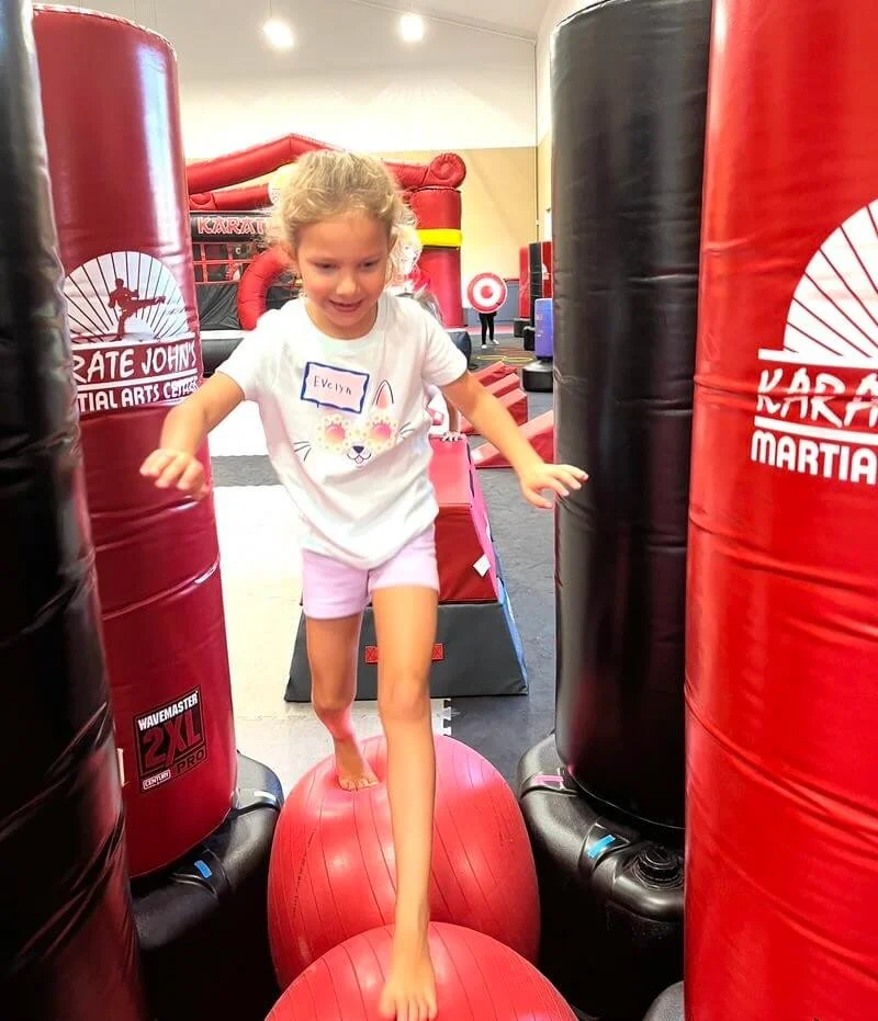 Girl moving through an obstacle course at summer camp at Karate John's in Cicero, NY.
