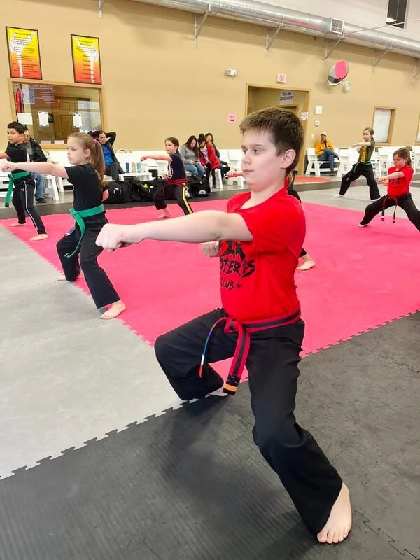 Teen boy practicing punches in a horse stance at Karate John's Martial Arts in Cicero and Liverpool, NY.