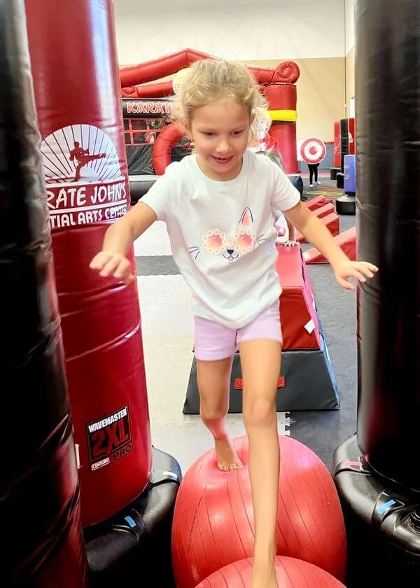 Young child improving balance, agility and coordination during a kids martial arts class birthday party at Karate John’s Martial Arts Center in Cicero and Liverpool, NY.