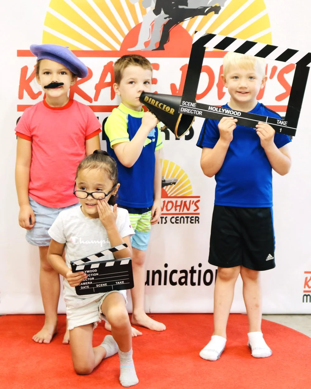 Group of kids posing as movie directors at Cicero summer camp at Karate John's.