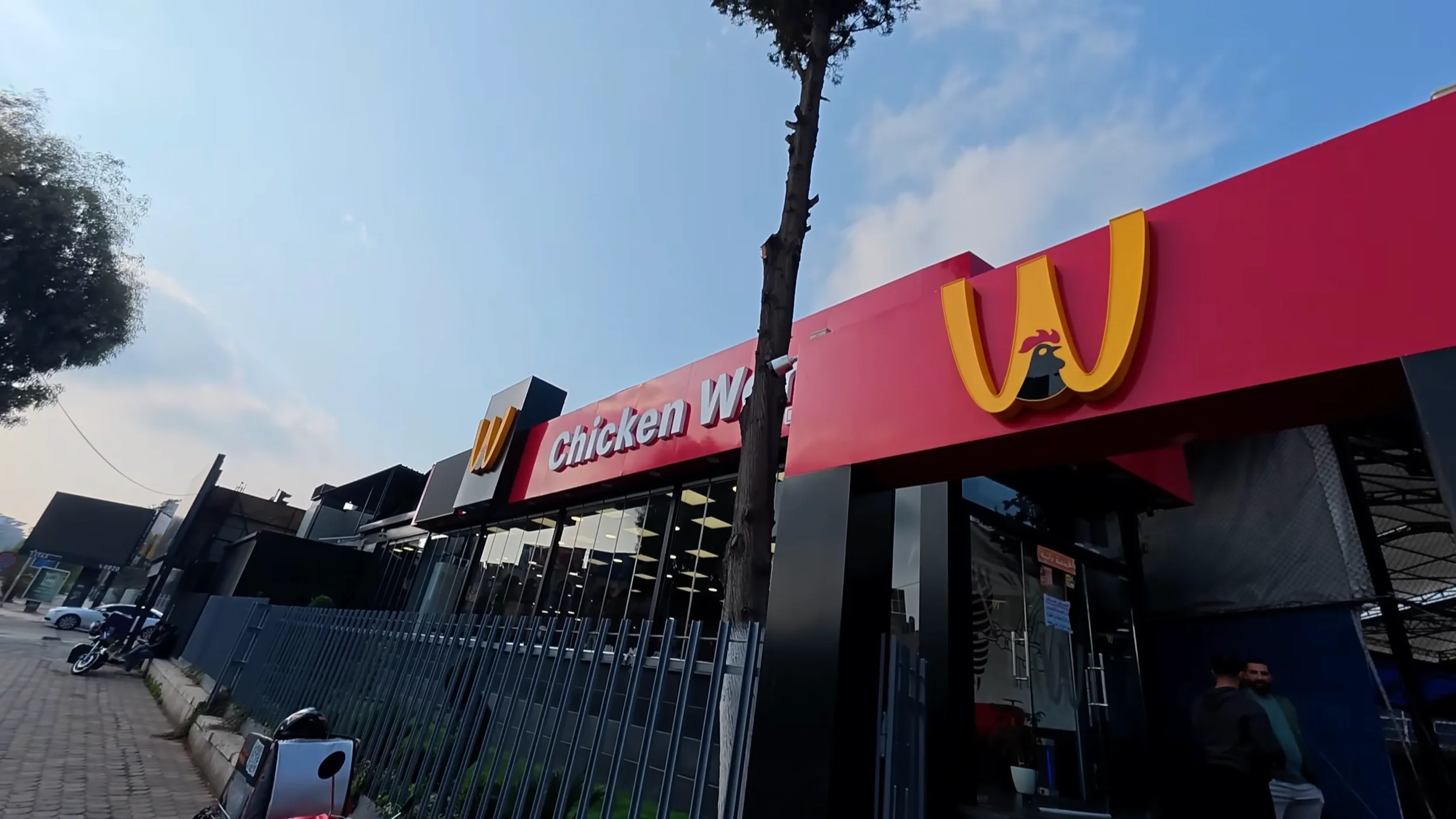 Chicken World storefront with upside-down M logo