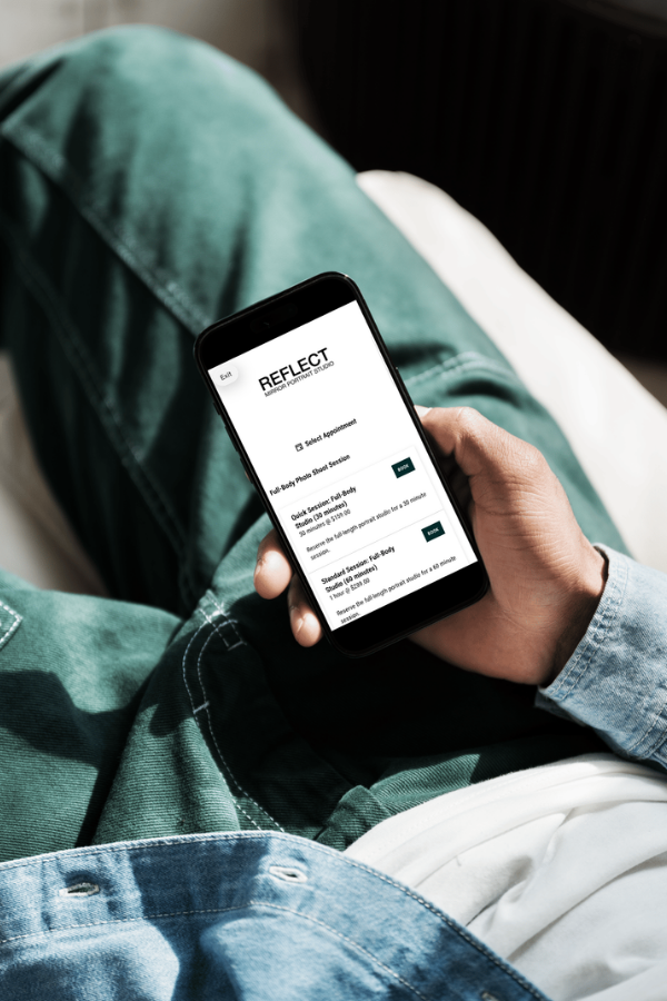 A held phone displays a booking page