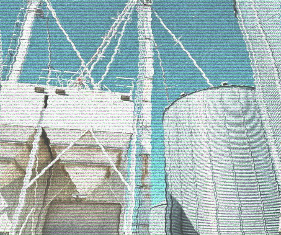 View of a white boat docked at a pier with a ferris wheel in the background