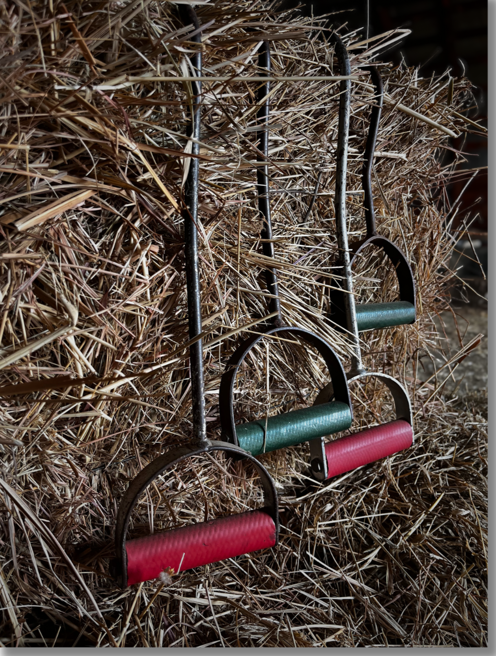 Two sets of hay hooks hanging on a hay bale.