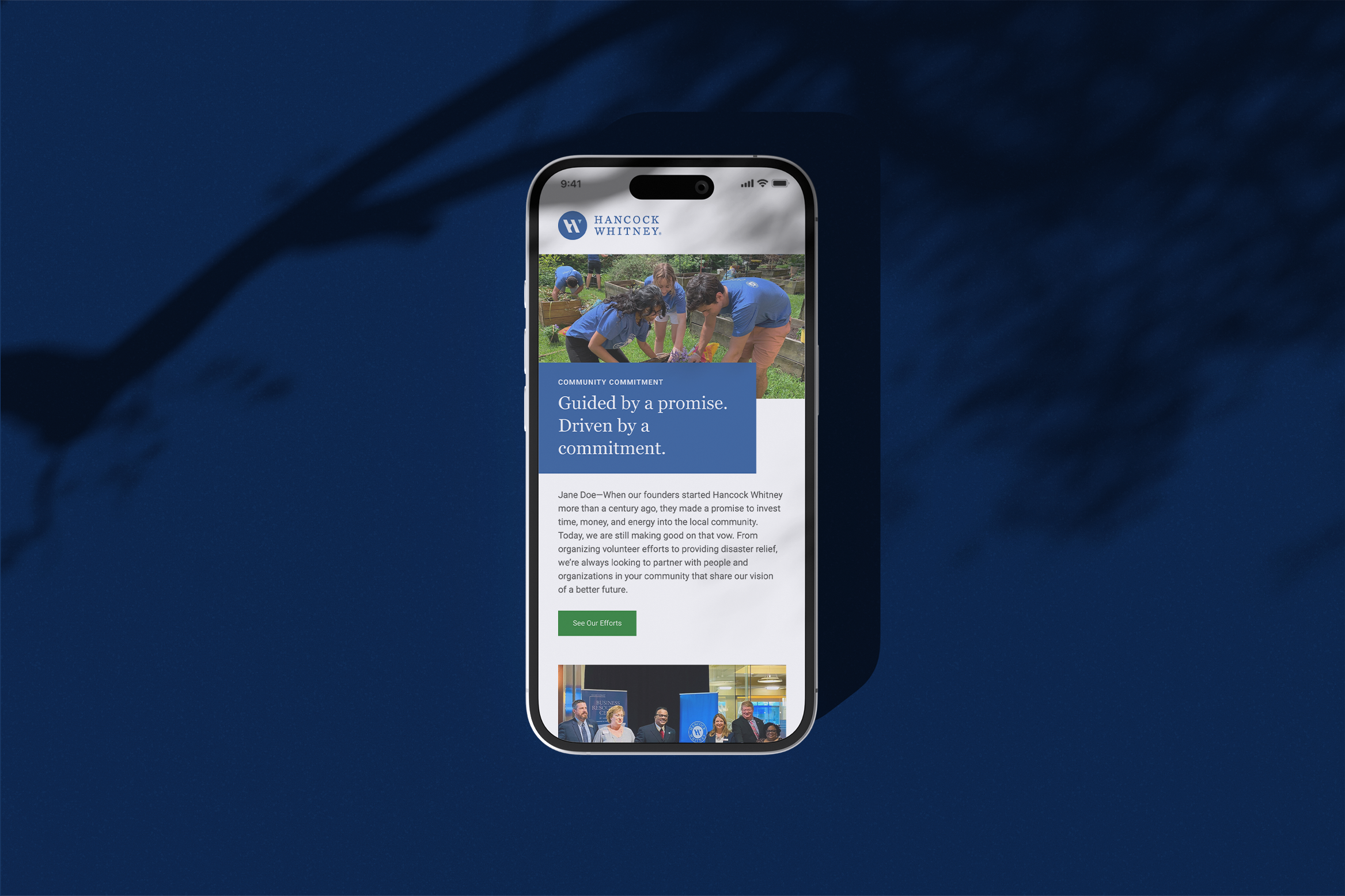 Mobile phone displaying Hancock Whitney website with a photo of people volunteering and a section of text about community commitment.