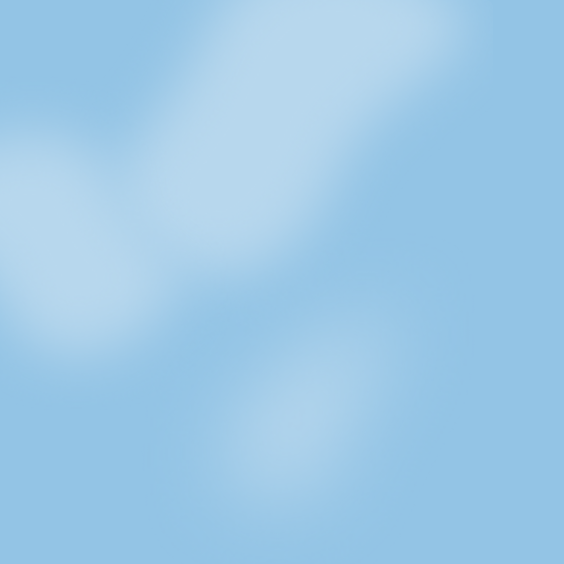 A pale blue sky with scattered soft, fluffy clouds.