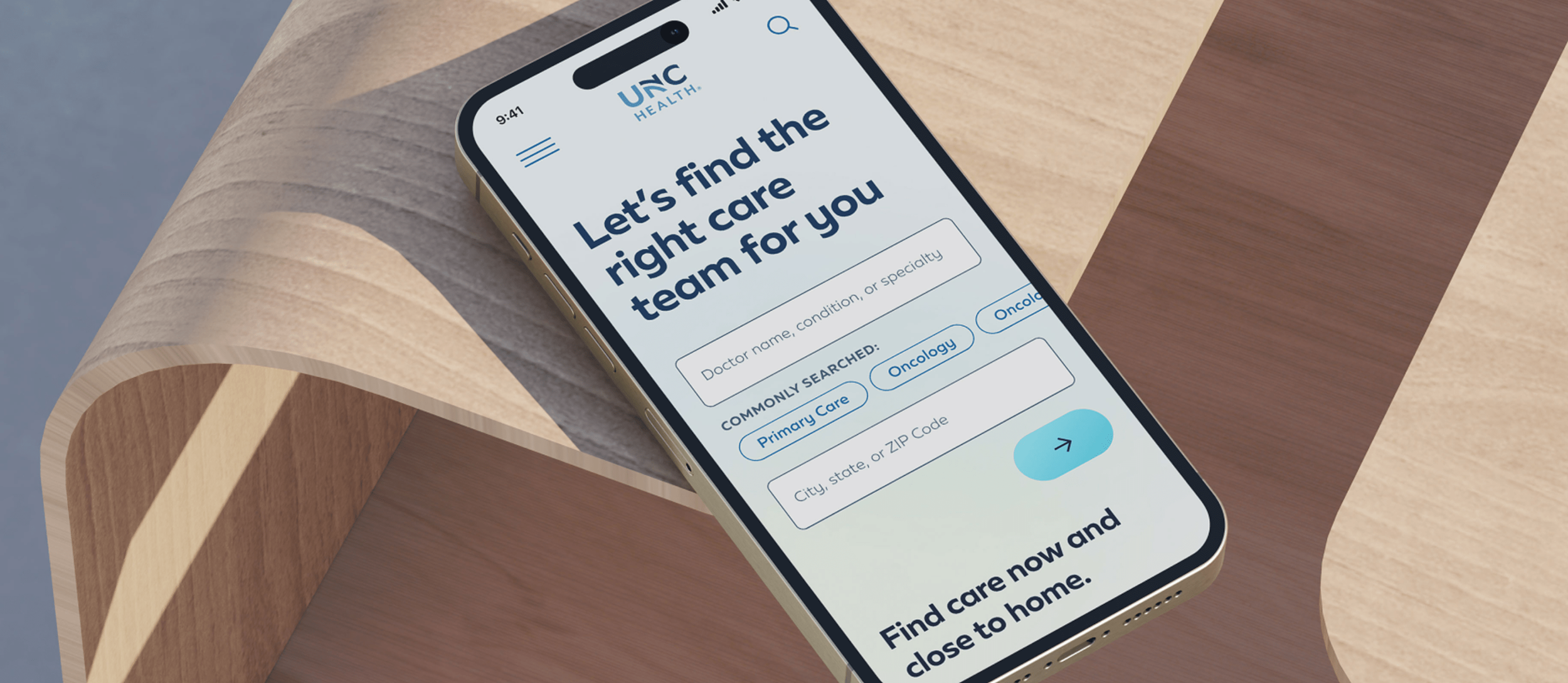 A smartphone displaying a healthcare app titled "Let's find the right care team for you" on a wooden table.