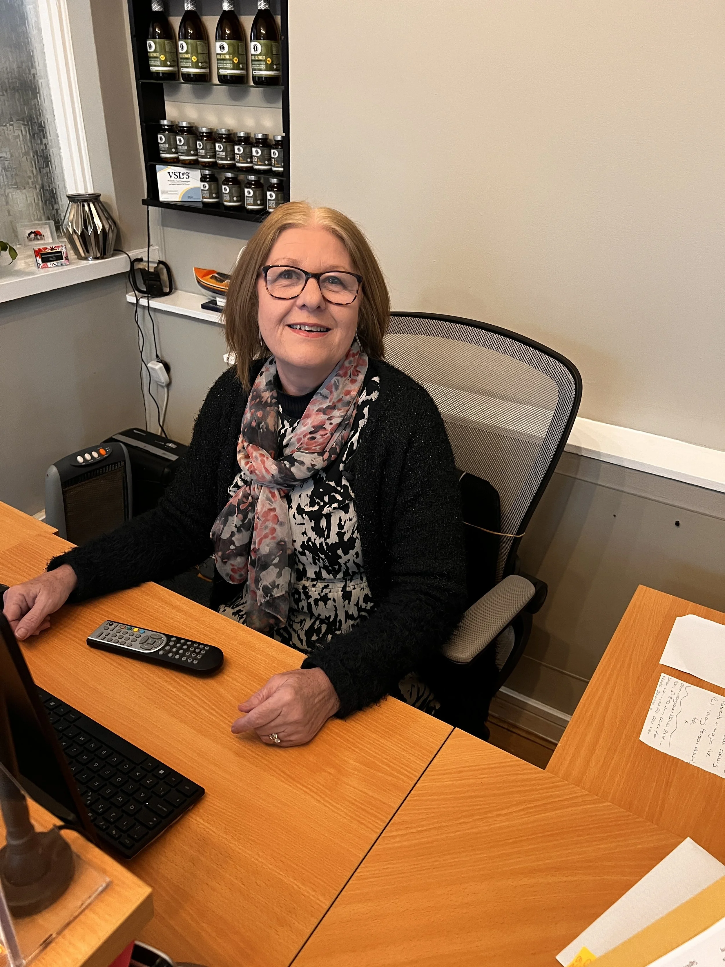 Smiling receptionist at her desk at leigh injection clinic