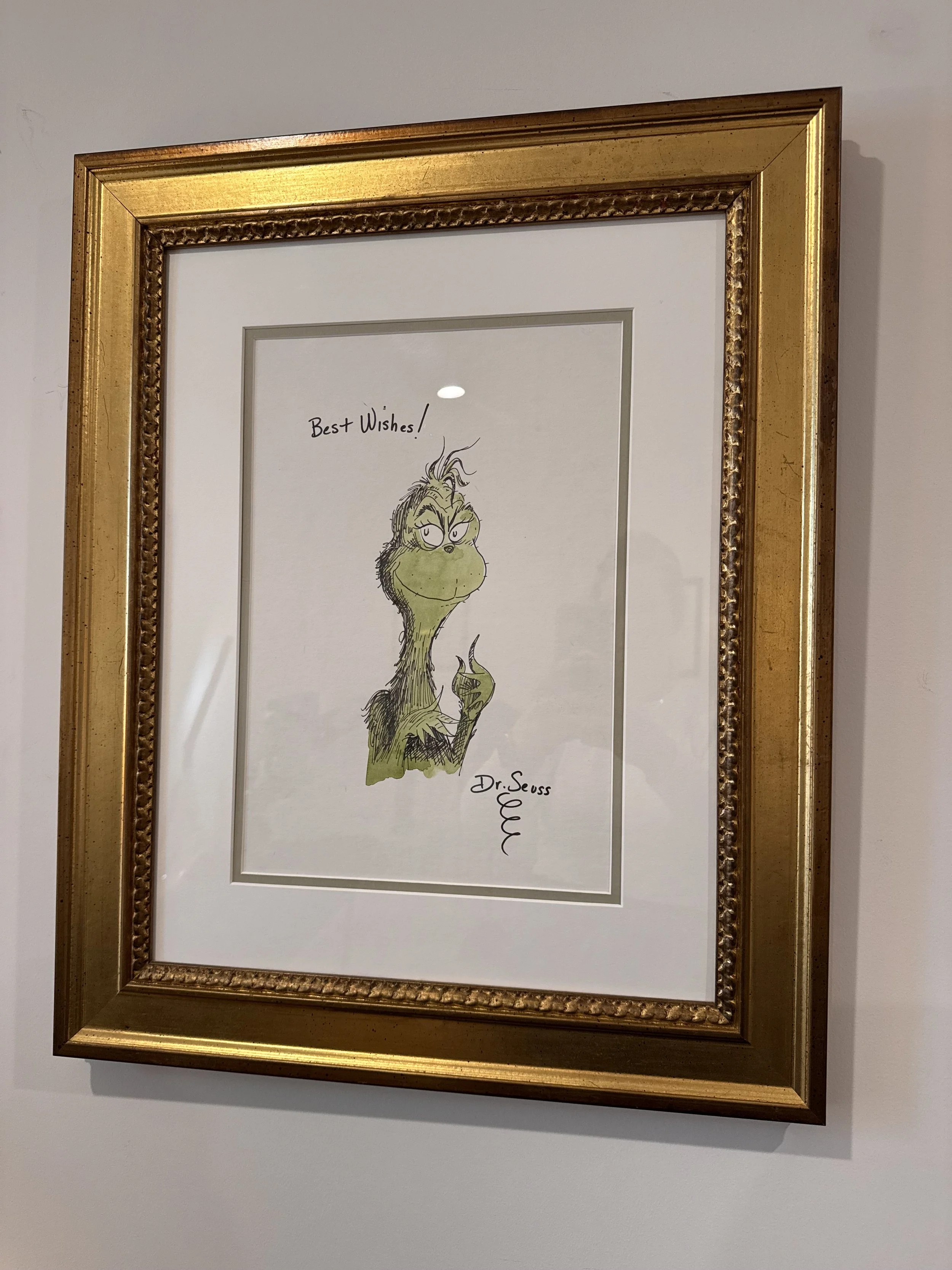 Framed illustration of the Grinch from Dr. Seuss, with the words "Best Wishes!" written above.