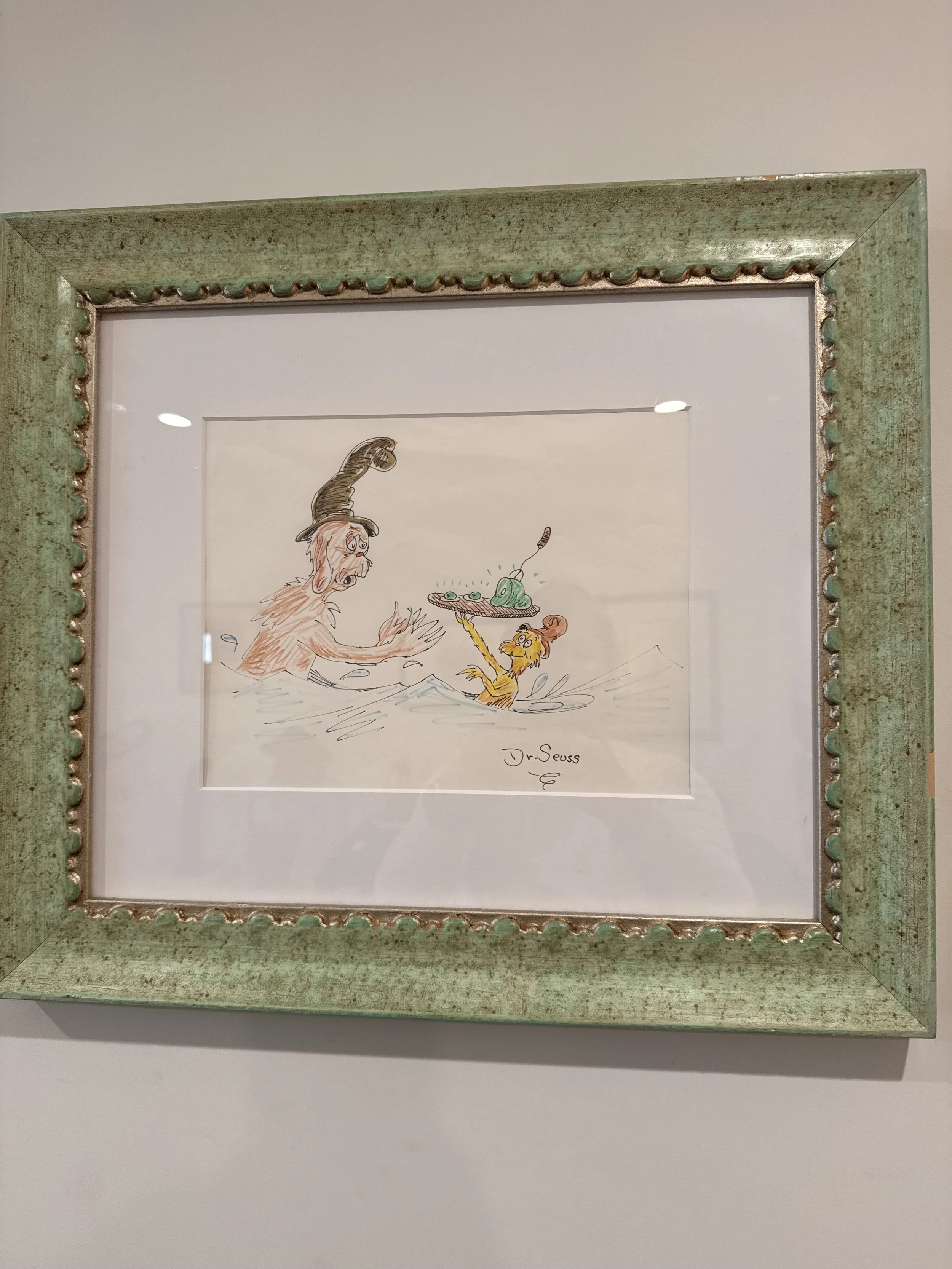 A framed illustration of Dr. Seuss characters in water, including a dog and a monkey, with the signature 'Dr. Seuss' at the bottom.