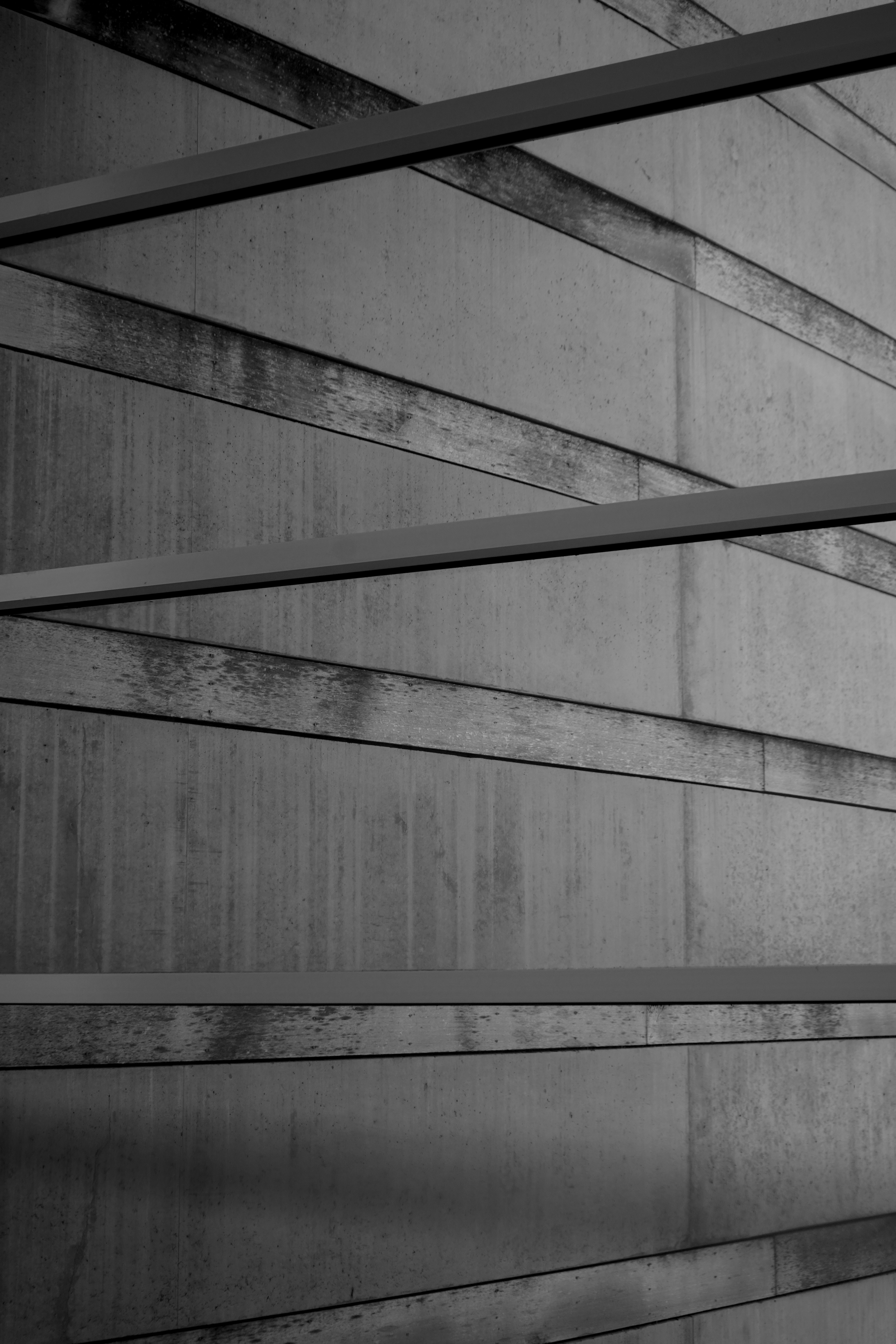 Black and white photo of modern architectural concrete structure with horizontal lines and sharp angles.