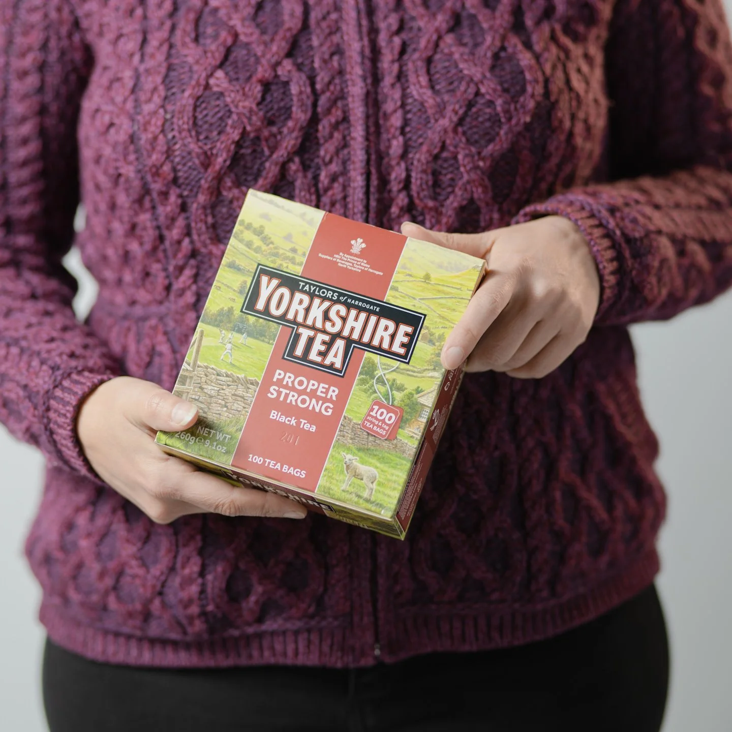 Person holding a box of Yorkshire Tea Proper Strong Black Tea